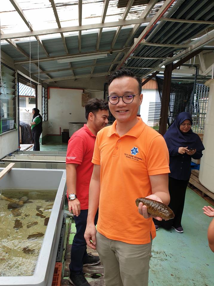 Sean Lee the Exhibits and Education Manager holding on to a sea cucumber. 