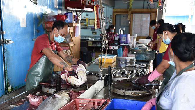 Workers at the Hai Seng Huat Fishery in Sekinchan descale, gut and clean customers' purchases with practised efficiency. (Photo: Vincent Tan)
